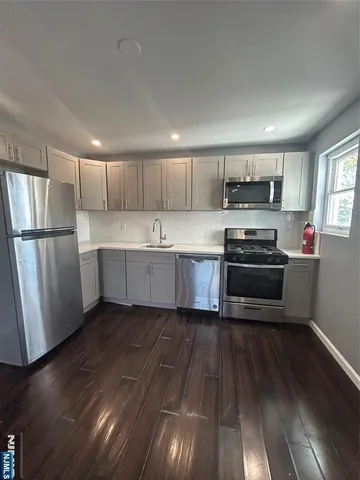 a kitchen with stainless steel appliances a refrigerator sink and microwave