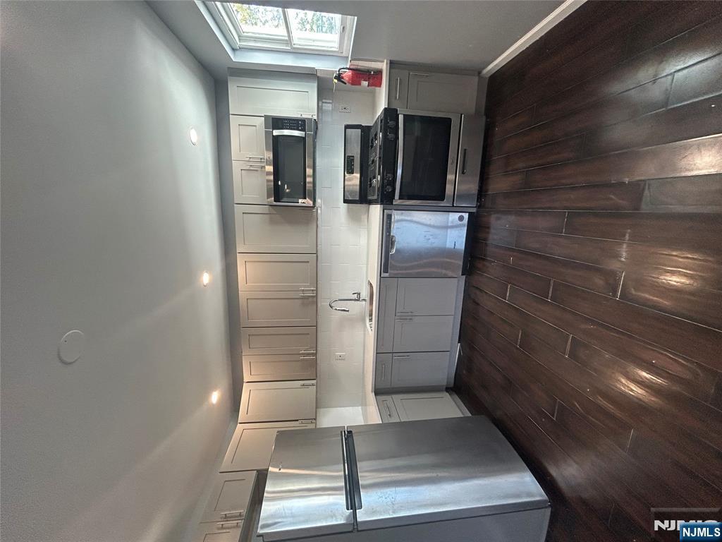a kitchen with stainless steel appliances a refrigerator sink and microwave