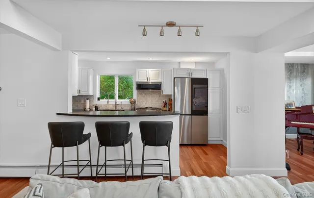 a kitchen with stainless steel appliances granite countertop a sink and a refrigerator