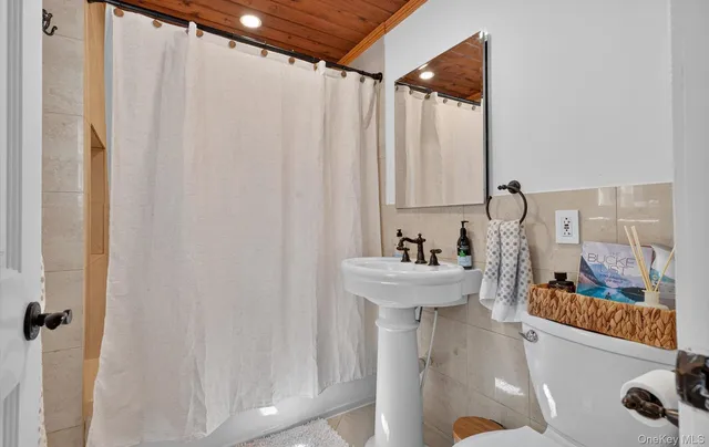 a bathroom with a sink and mirror with bathtub