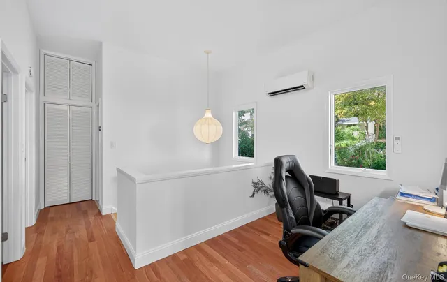 a view of a workspace with furniture and a window