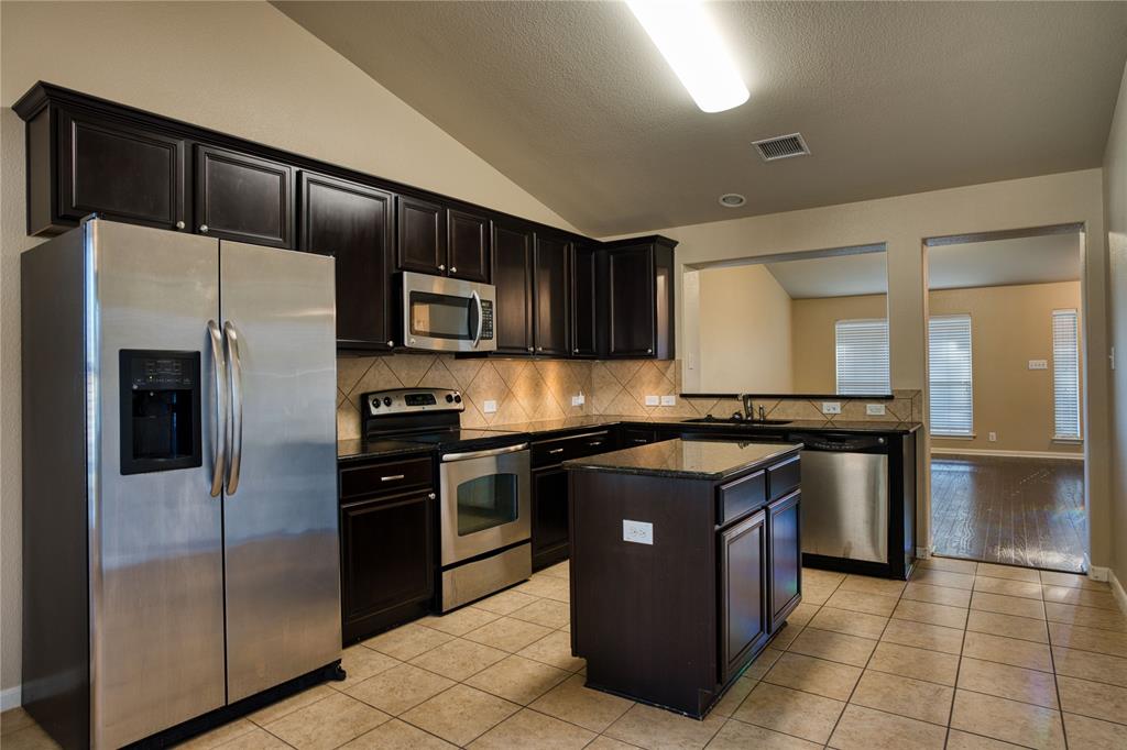 821 Gabriel Mills Drive Round Rock, TX 78664 - Photo 5 of 15 a kitchen with stainless steel appliances granite countertop a stove a refrigerator and a sink