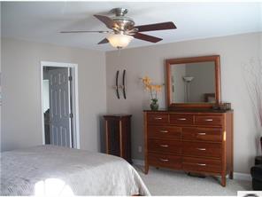 141 Surfside Road Mooresville, NC 28117 - Photo 11 of 16 a bedroom with a bed and a mirror on dresser