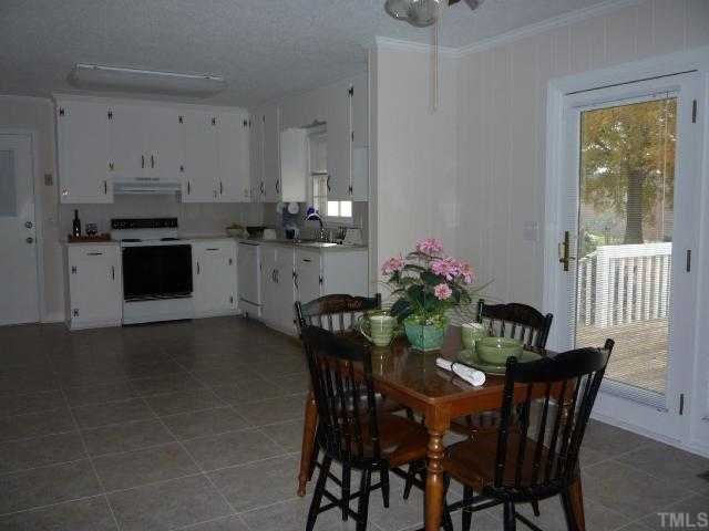 4135 Mebane Rogers Road Mebane, NC 27302 - Photo 6 of 12 Another view of the spacious eat-in kitchen showing the patio doors to the deck at right. Door at left leads to the oversized 2 car garage with beadboard interior and additional storage room.