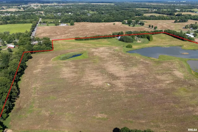 an aerial view of a house with a garden and lake view