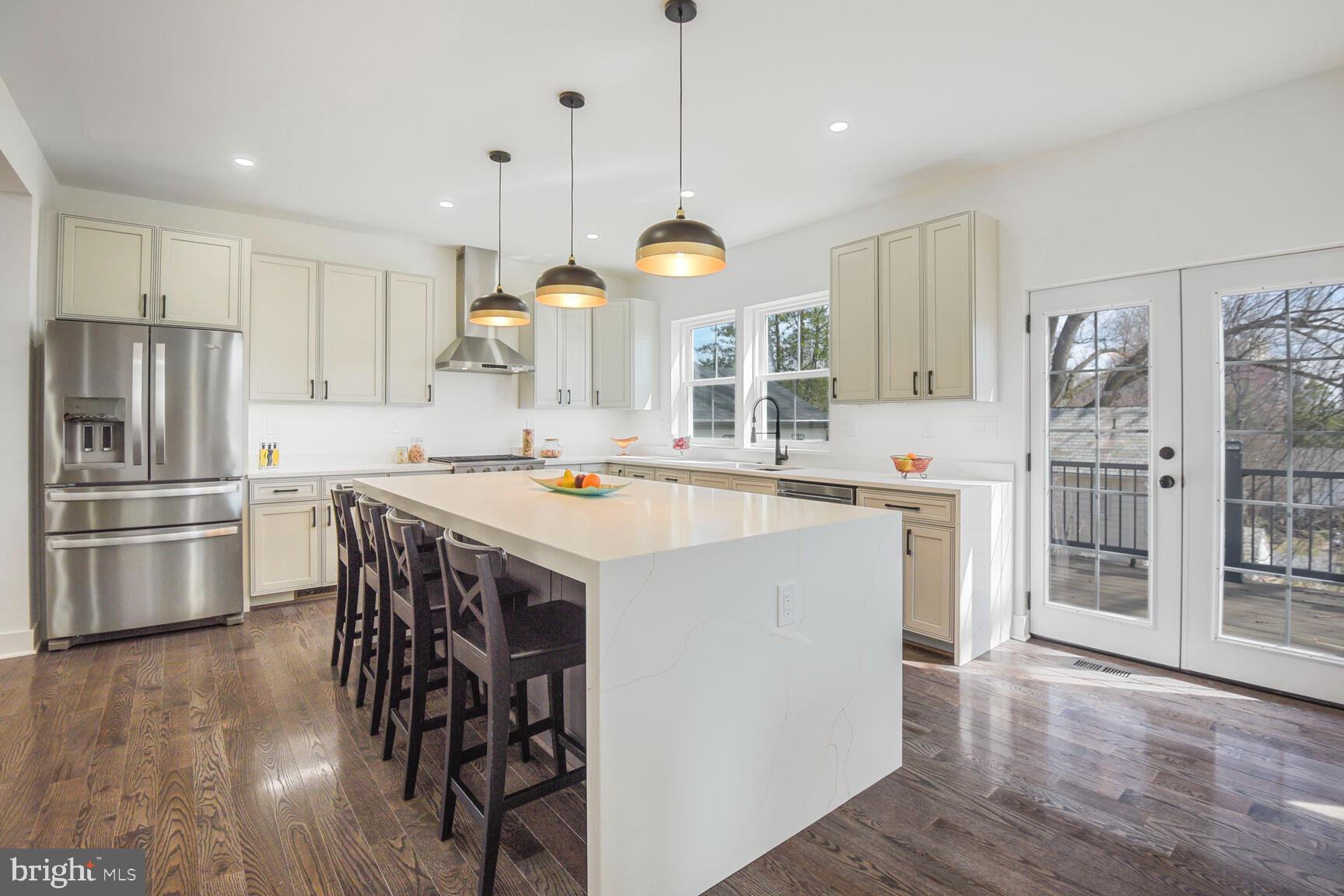 1612 Noyes Drive Silver Spring, MD 20910 - Photo 4 of 37 a kitchen with stainless steel appliances a stove a sink dishwasher a refrigerator and a dining table with wooden floor