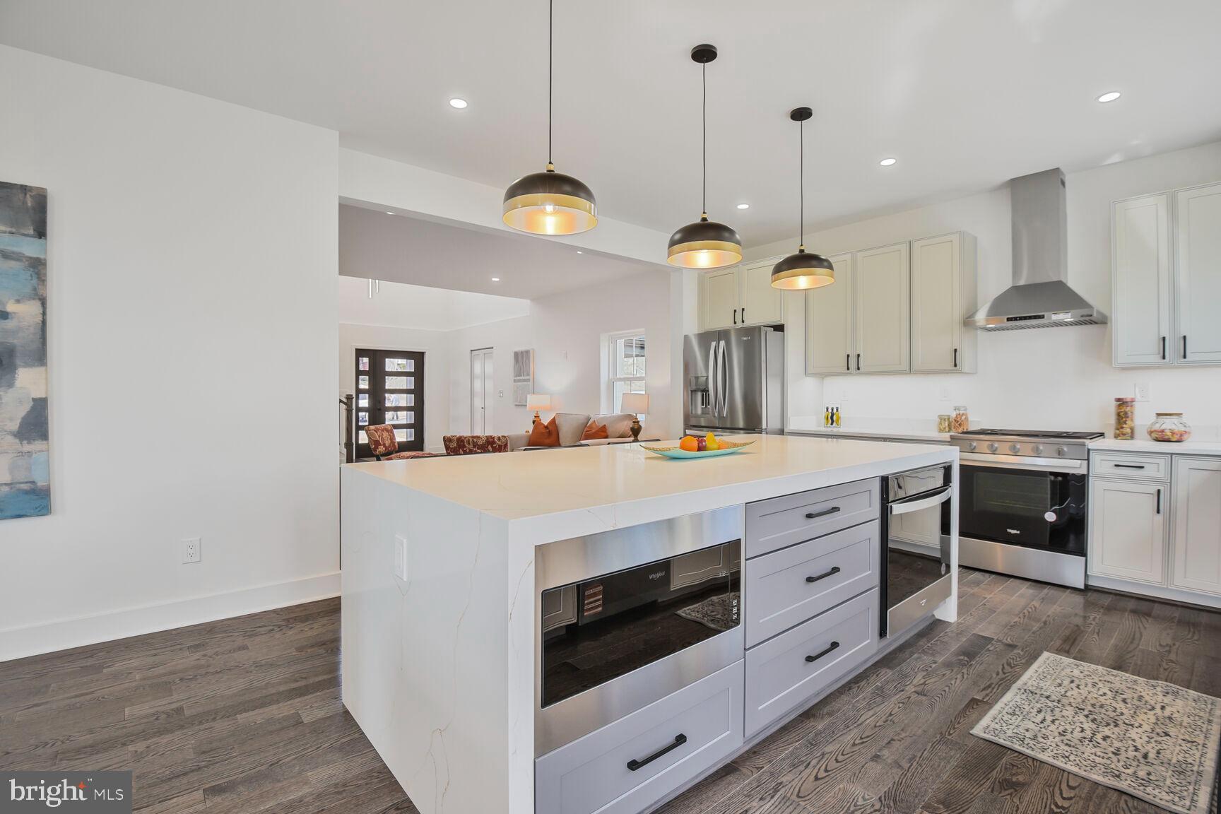 1612 Noyes Drive Silver Spring, MD 20910 - Photo 7 of 37 a kitchen with kitchen island white cabinets and stainless steel appliances