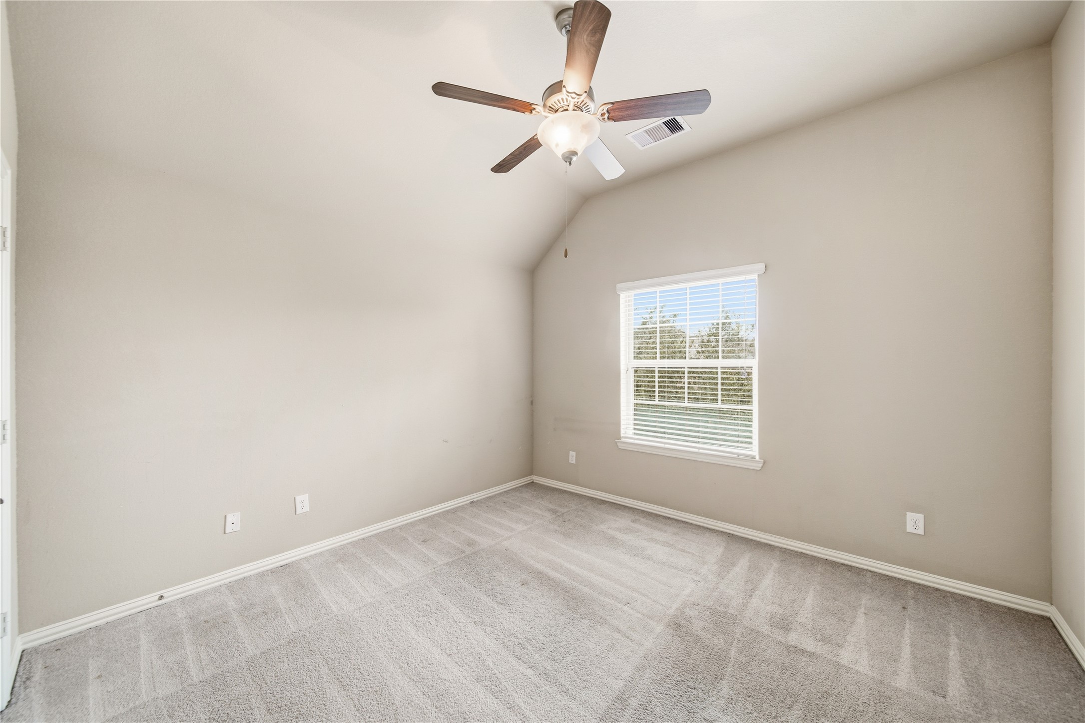 5303 Mesquite Willow Lane Rosharon, TX 77583 - Photo 26 of 32 This bright bedroom features neutral walls, a ceiling fan, and a large window with blinds, offering a comfortable and airy atmosphere. Plush carpeting adds coziness to the space.