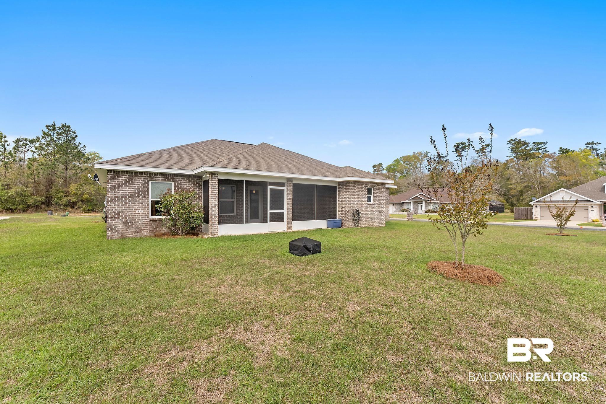 32868 Arbor Ridge Circle Lillian, AL 36549 - Photo 33 of 35 Back of house with brick siding, a lawn, a sunroom, and a shingled roof