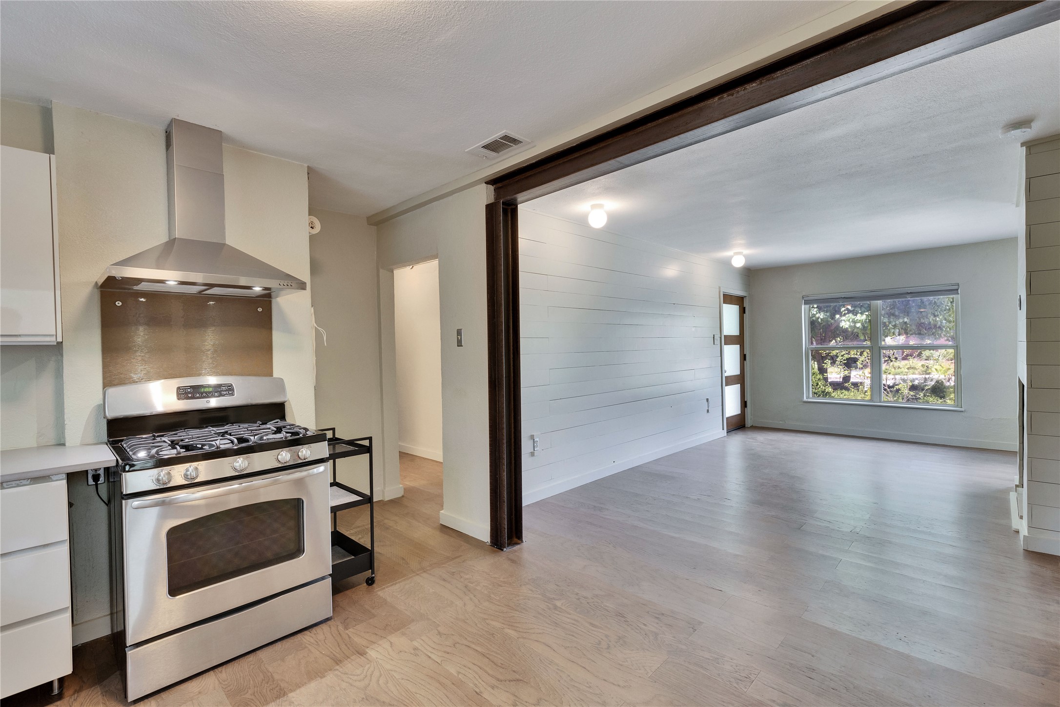 1306 Norwood Road, Unit A Austin, TX 78722 - Photo 11 of 21 A well-equipped kitchen transitions to an airy living space with light wood flooring and outdoor views.