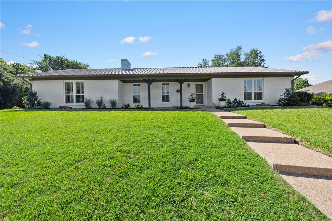 a front view of a house with a garden and yard