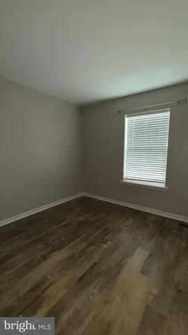 an empty room with wooden floor and a window