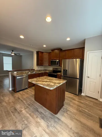 a kitchen with stainless steel appliances granite countertop a stove top oven a refrigerator and a sink
