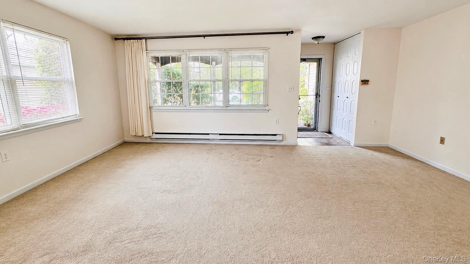 257 Edinburgh Drive Ridge, NY 11961 - Photo 3 of 10 an empty room with windows and closet