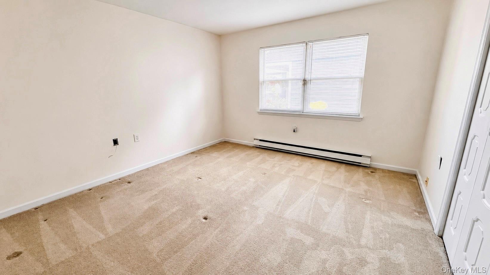 257 Edinburgh Drive Ridge, NY 11961 - Photo 7 of 10 an empty room with a window