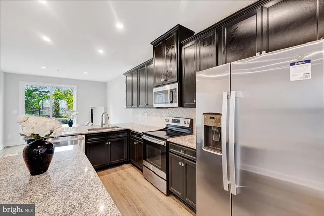 a kitchen with stainless steel appliances granite countertop a refrigerator and a sink
