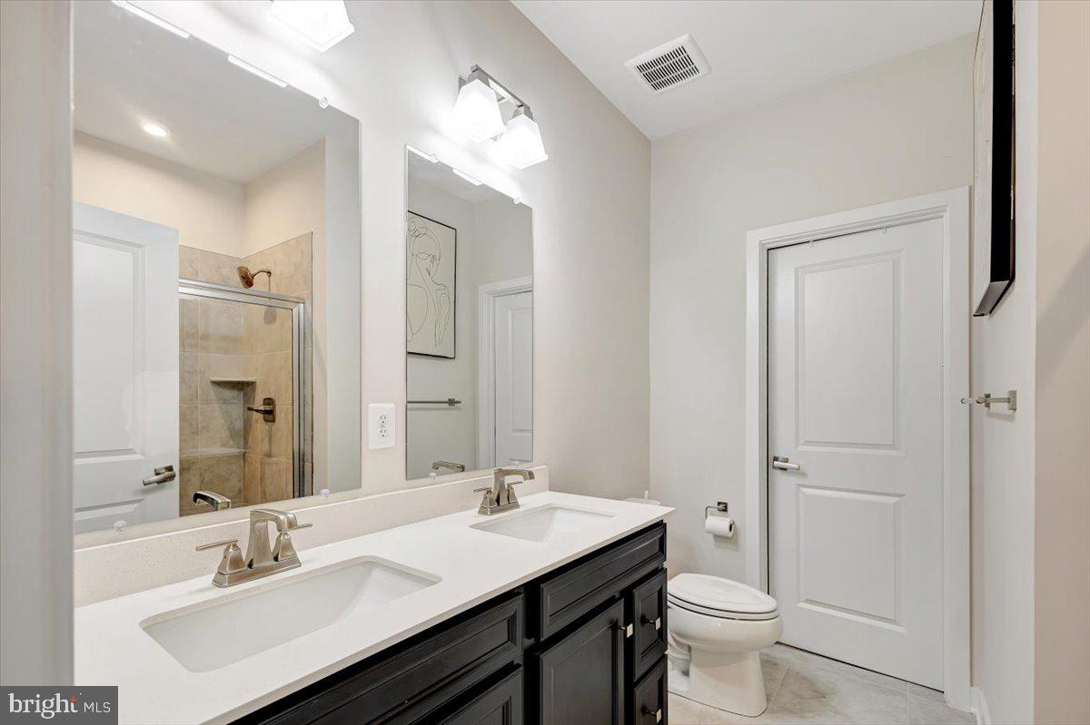 7157 Smoke Stack Road Baltimore, MD 21222 - Photo 18 of 27 a bathroom with a sink toilet a mirror and vanity