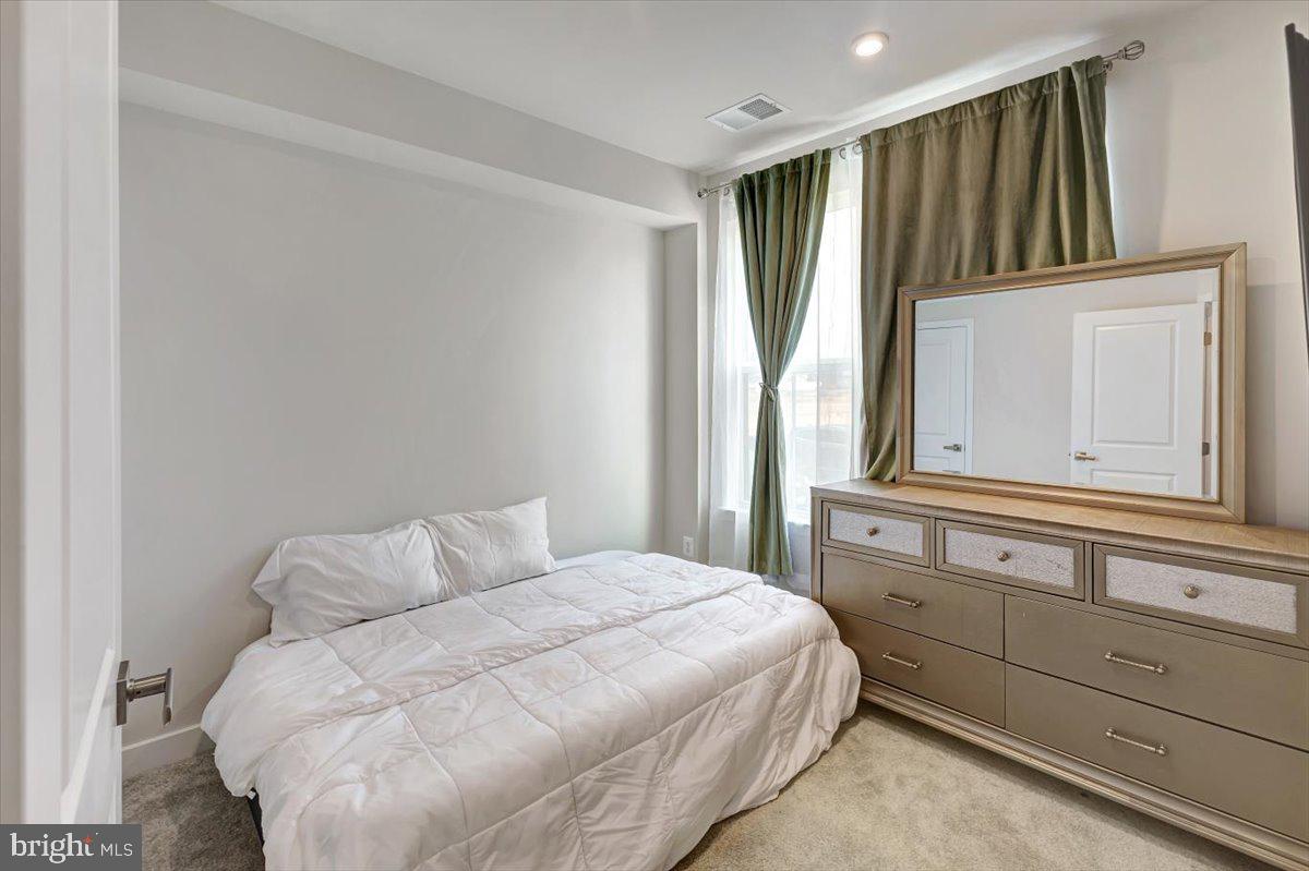 7157 Smoke Stack Road Baltimore, MD 21222 - Photo 4 of 27 a bedroom with a bed mirror and window