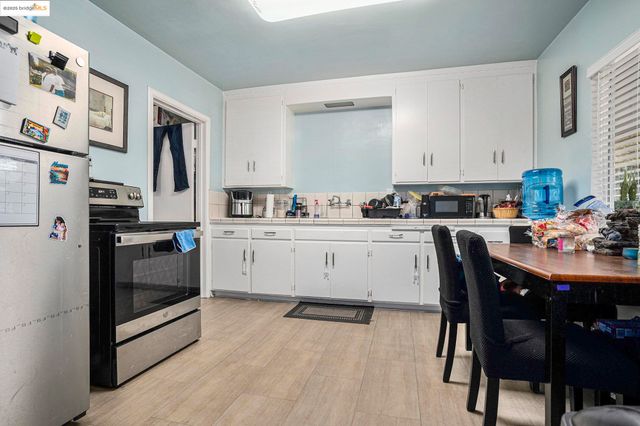 a view of a kitchen with fridge and workspace