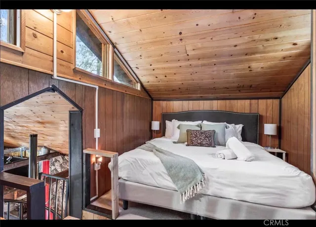 a bedroom with a bed a mirror and lamp