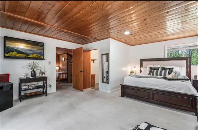 a spacious bedroom with a bed and a flat screen tv