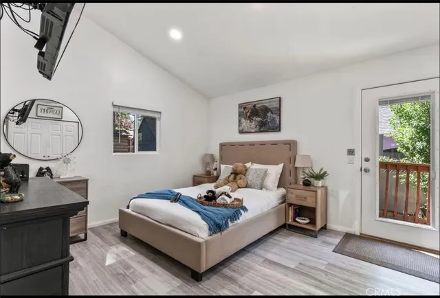 a bedroom with a bed a mirror and a potted plant