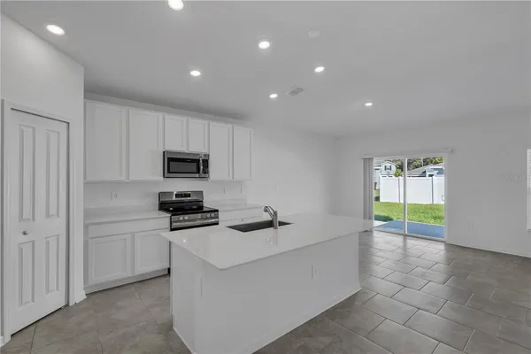 a kitchen with granite countertop a sink a stove cabinets and counter space
