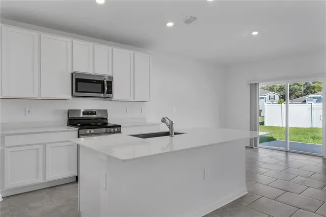 a kitchen with a sink a stove and cabinets