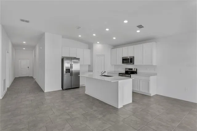 a kitchen with stainless steel appliances a refrigerator sink and stove
