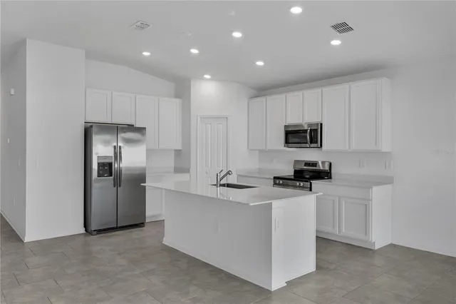 a kitchen with cabinets and stainless steel appliances