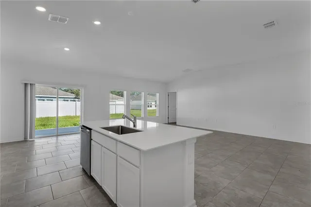 a kitchen with stainless steel appliances granite countertop a sink and a white cabinets