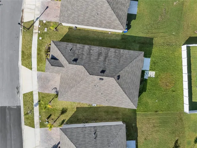 an aerial view of a house with a yard