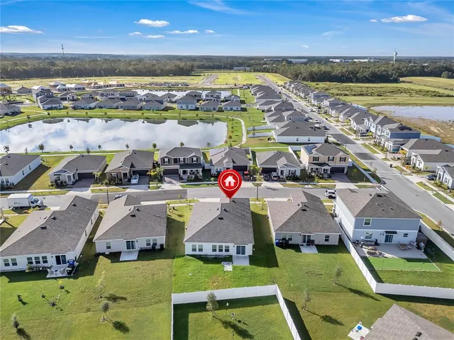 an aerial view of residential houses with outdoor space and ocean view