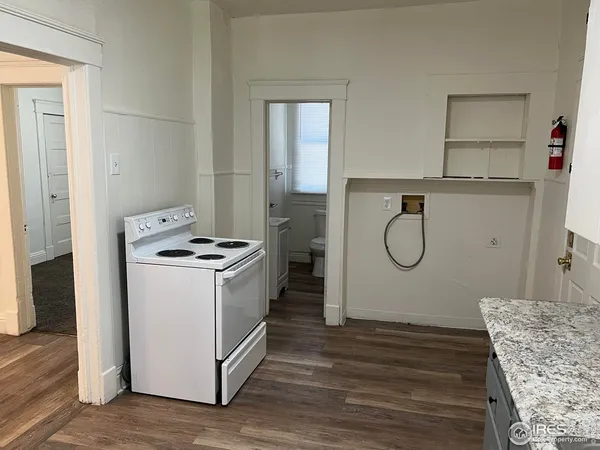 a kitchen with a stove a refrigerator and a wooden floor