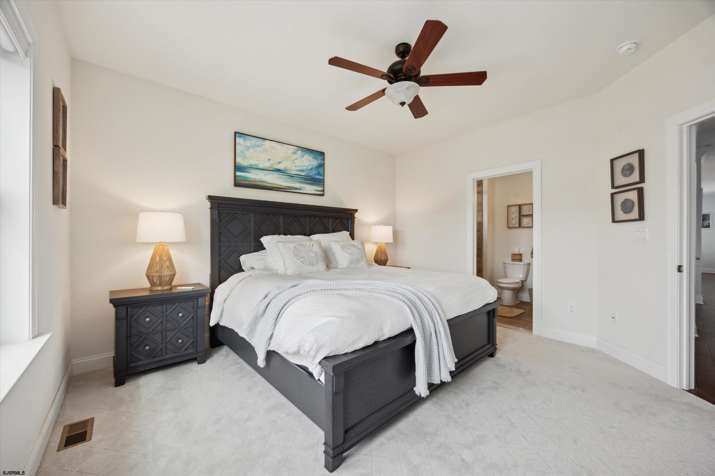 235 35th Street South Brigantine, NJ 08203 - Photo 14 of 56 a spacious bedroom with a bed and a ceiling fan