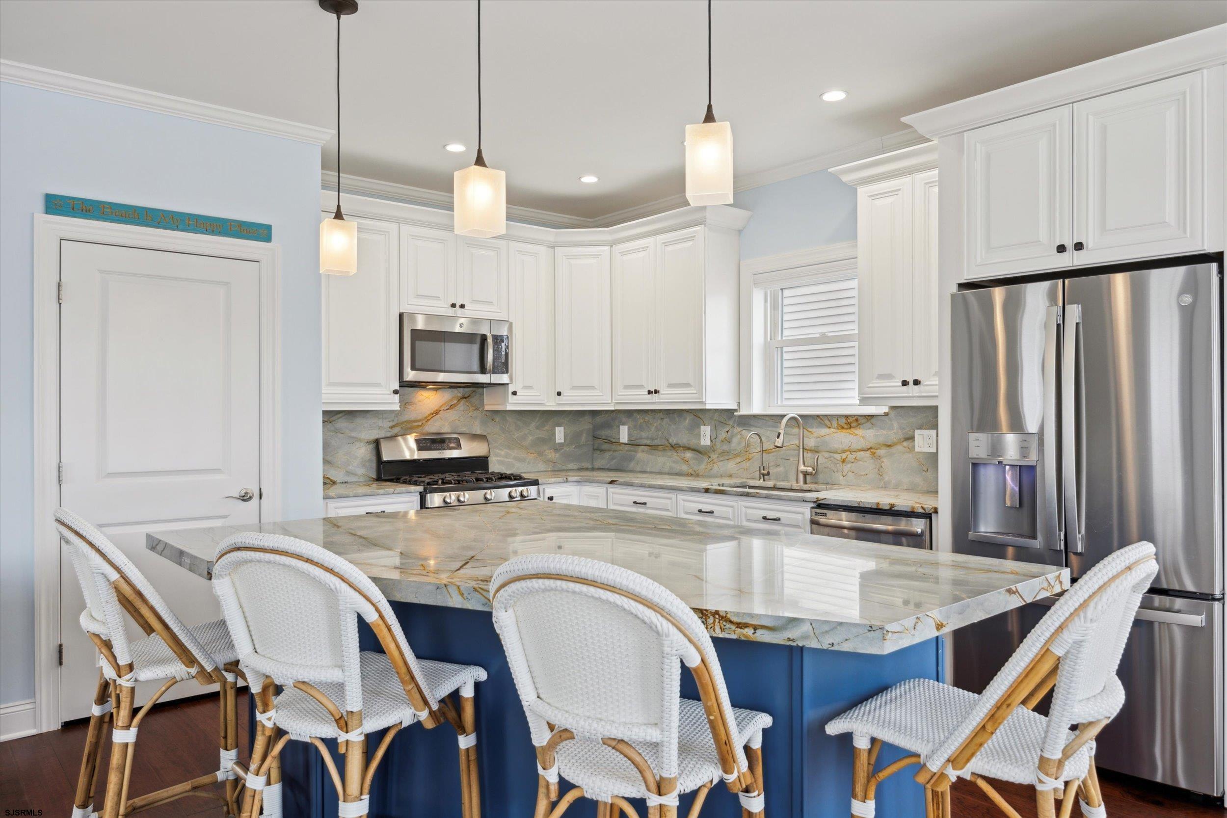 235 35th Street South Brigantine, NJ 08203 - Photo 17 of 56 a kitchen with stainless steel appliances granite countertop a sink a stove a refrigerator cabinets and chairs