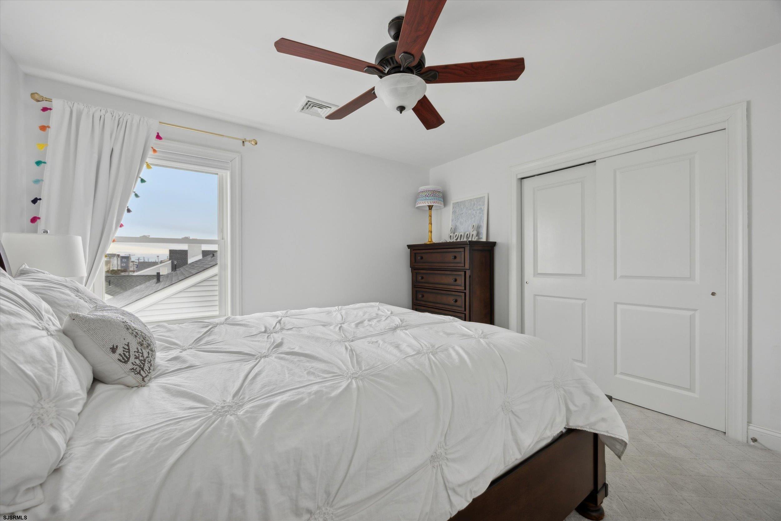 235 35th Street South Brigantine, NJ 08203 - Photo 9 of 56 a bedroom with a bed and a chandelier
