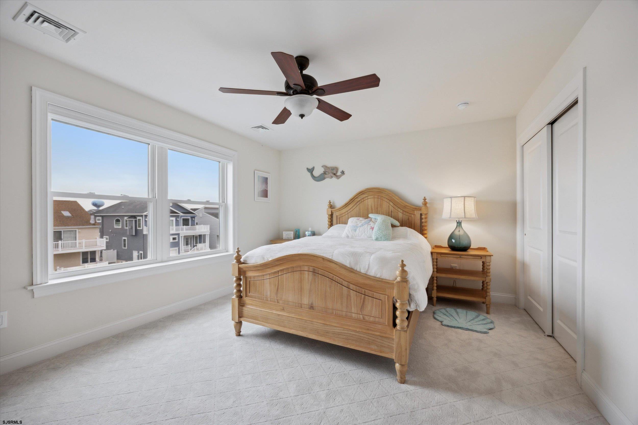 235 35th Street South Brigantine, NJ 08203 - Photo 10 of 56 a bedroom with a bed lamp and a large window