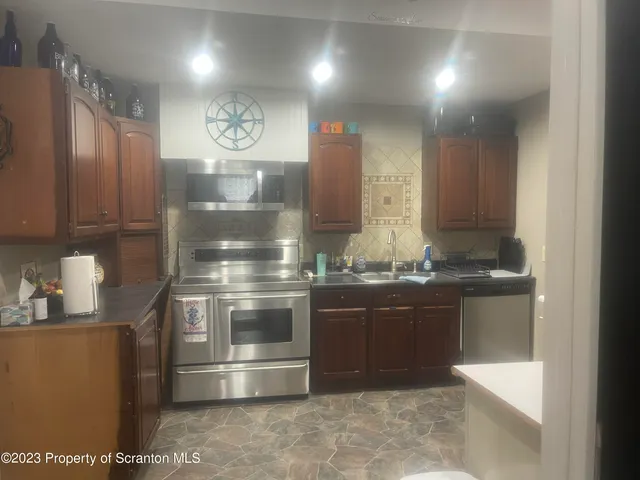 a kitchen with stainless steel appliances granite countertop a refrigerator and a sink