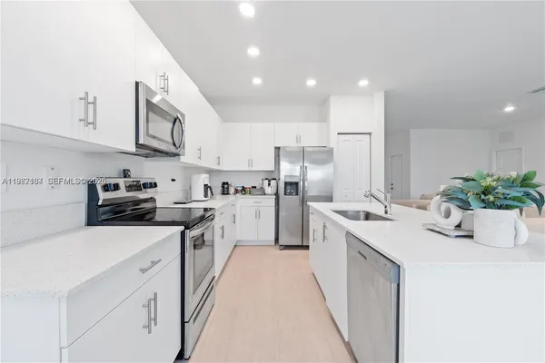 a kitchen with stainless steel appliances kitchen island granite countertop a sink and cabinets