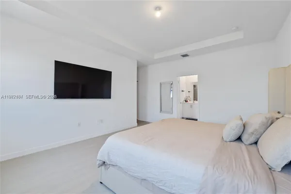 a bedroom with a bed and a flat screen tv