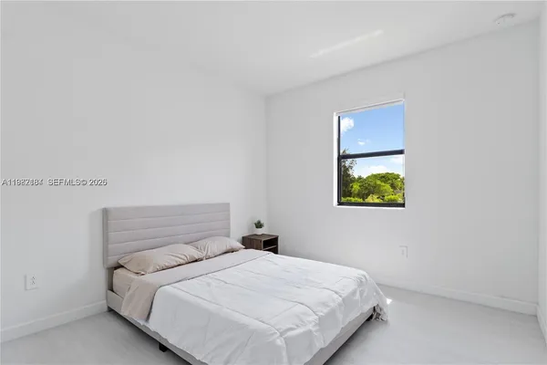 a bedroom with a bed and painting on the wall