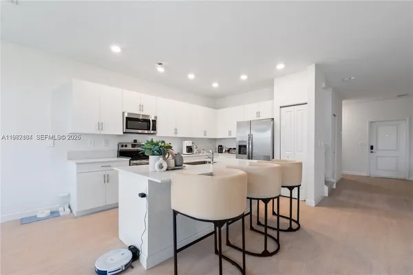a kitchen with stainless steel appliances kitchen island granite countertop a sink and cabinets