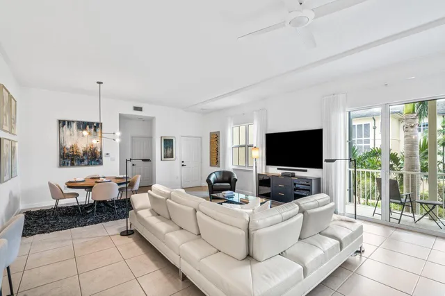 a view of a hallway with wooden floor and a living room