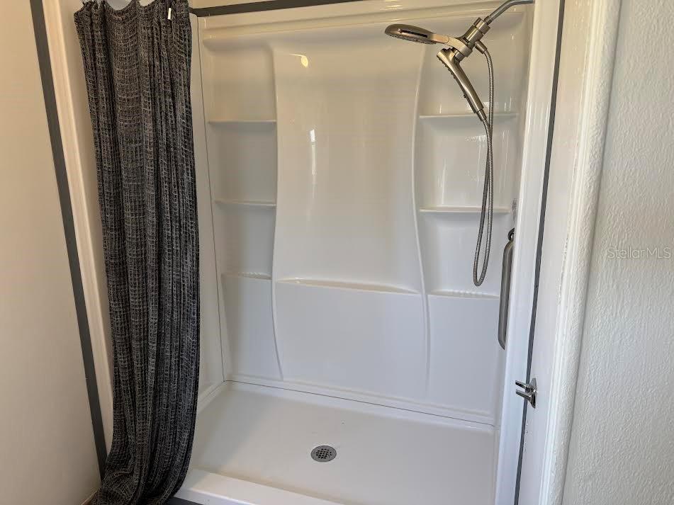 5168 Rubber Tree Circle New Port Richey, FL 34653 - Photo 17 of 36 a bathroom with a shower