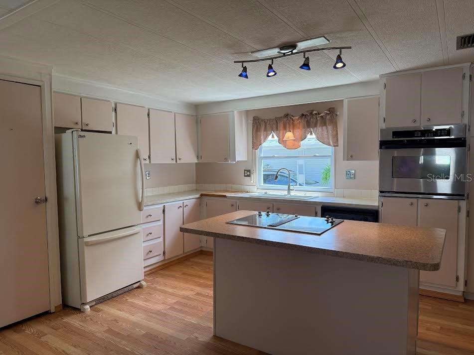 5168 Rubber Tree Circle New Port Richey, FL 34653 - Photo 6 of 36 a kitchen with stainless steel appliances granite countertop a refrigerator a stove a sink and a microwave