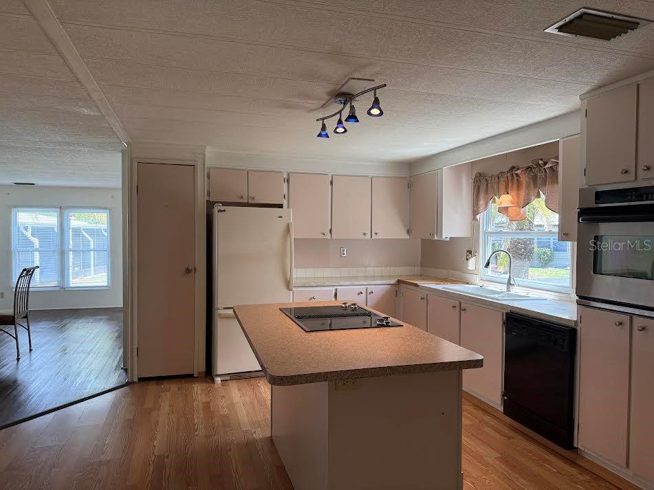 5168 Rubber Tree Circle New Port Richey, FL 34653 - Photo 7 of 36 a kitchen with a sink a stove a refrigerator cabinets and a window