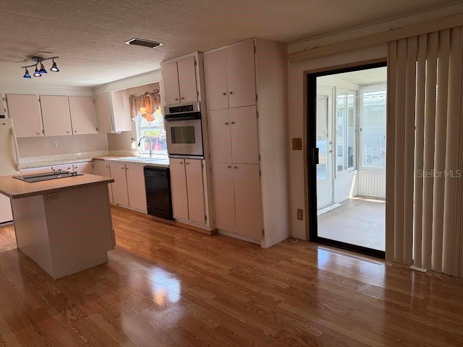 5168 Rubber Tree Circle New Port Richey, FL 34653 - Photo 9 of 36 a kitchen with stainless steel appliances granite countertop a refrigerator a sink a stove and oven with wooden floor