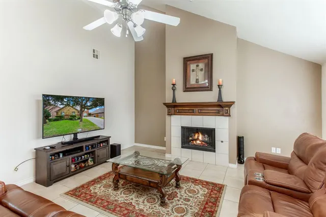 a living room with furniture a flat screen tv and a fireplace