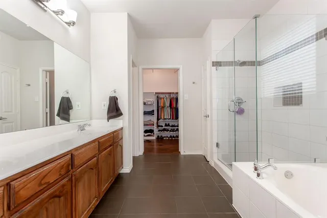 a spacious bathroom with a double vanity sink a large mirror and shower